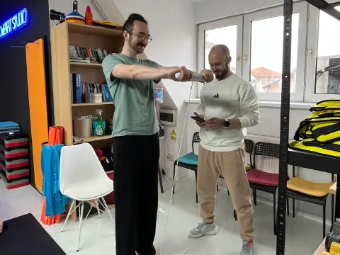 Antrenor EmpowerFit care face analiza compoziției corporale unui client, la evaluarea de personal training